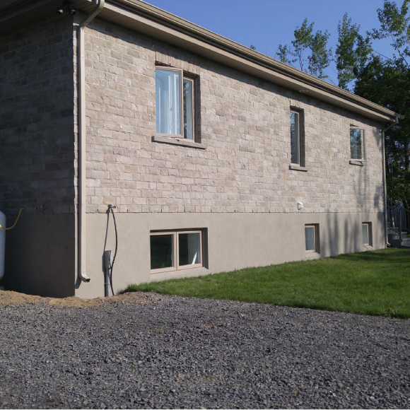 Finition esthétique d’une fondation de maison avec crépi acrylique