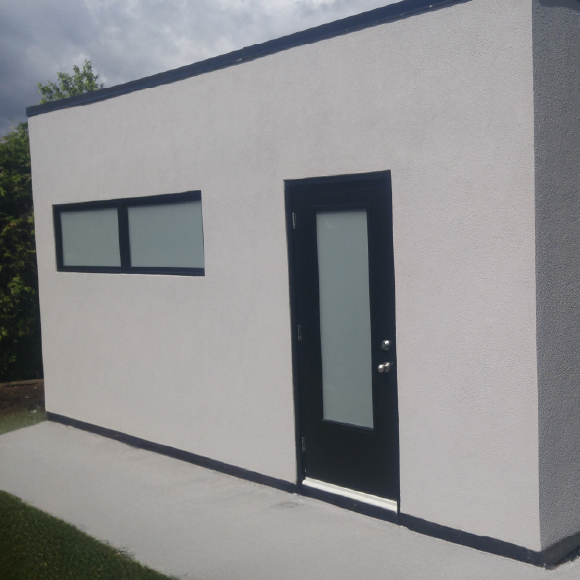 Application du revêtement extérieur pour un cabanon avec du crépi acrylique