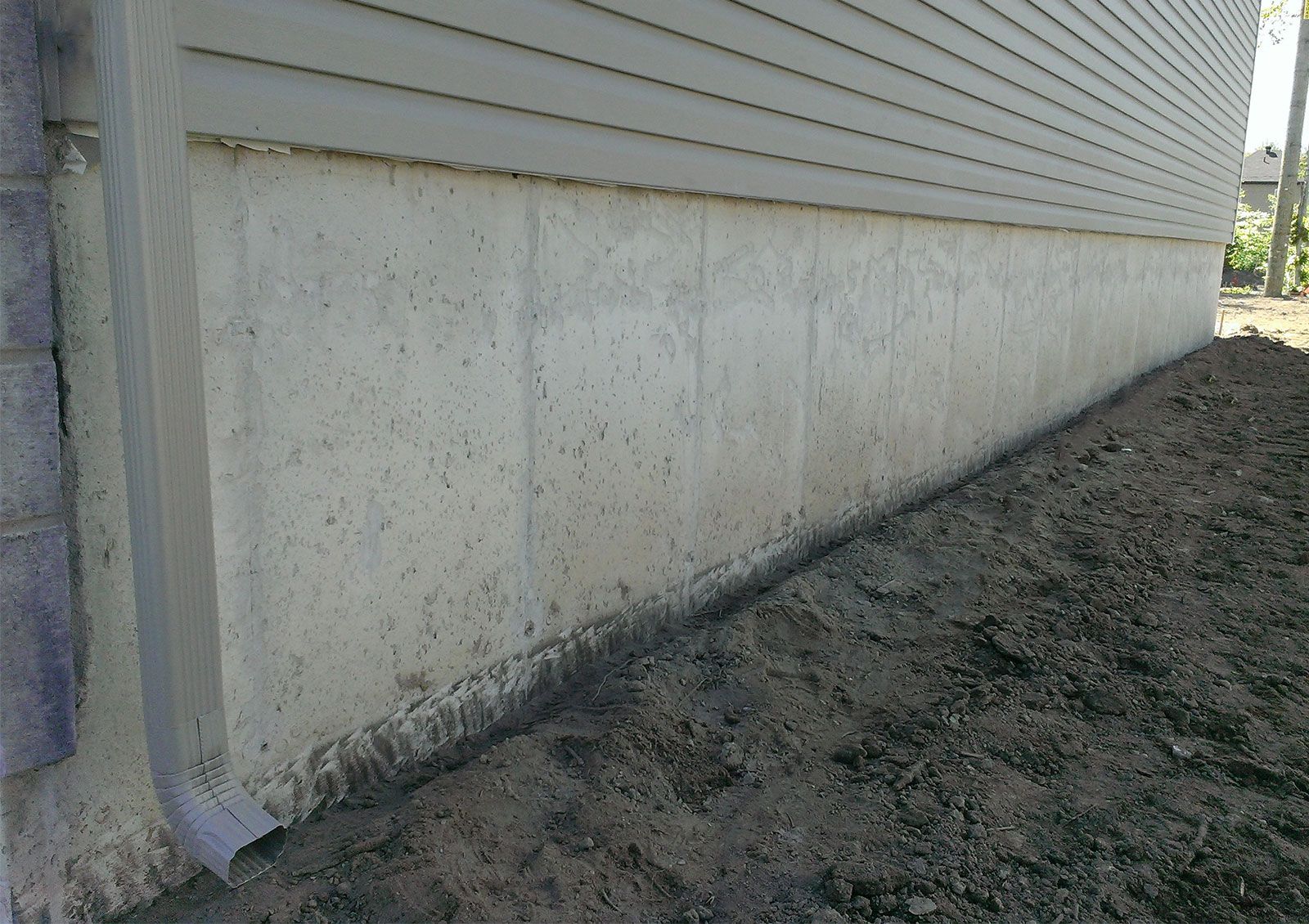 Application de crépi acrylique sur du béton coulé avant/après