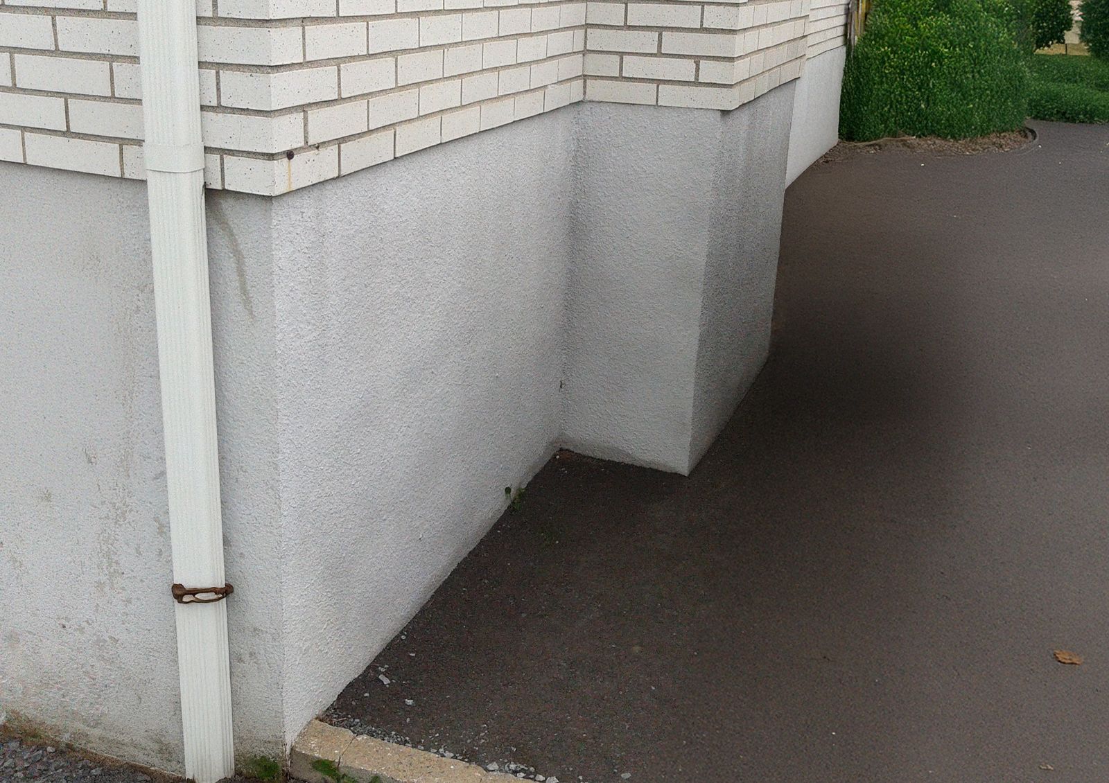 Application du crépi acrylique sur un mur en stucco, illustrant les étapes de préparation et d'enduit.